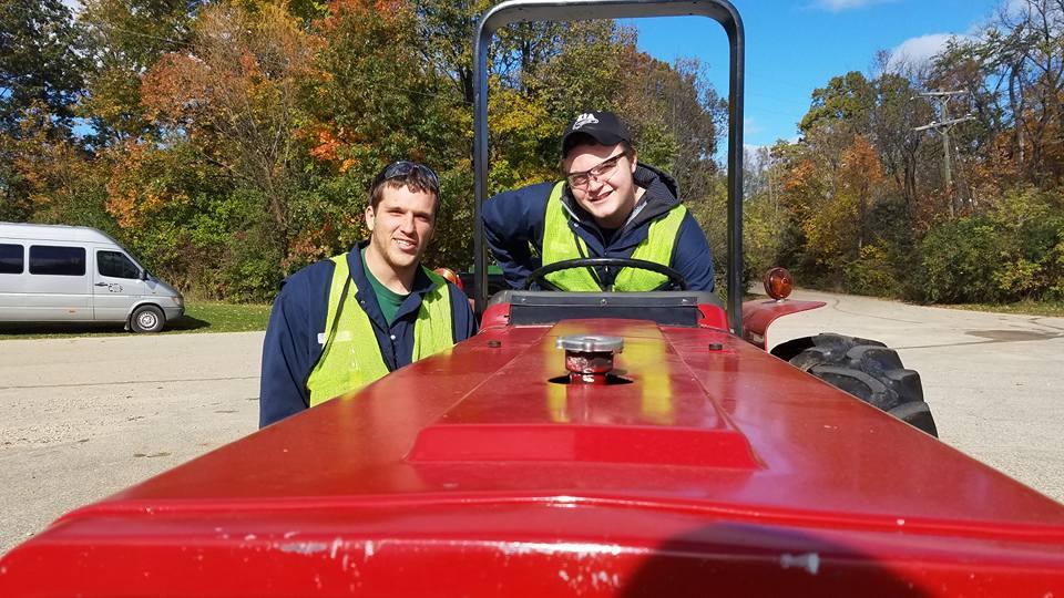 2 students posing for picture during operation of our Case 485 Tractor.